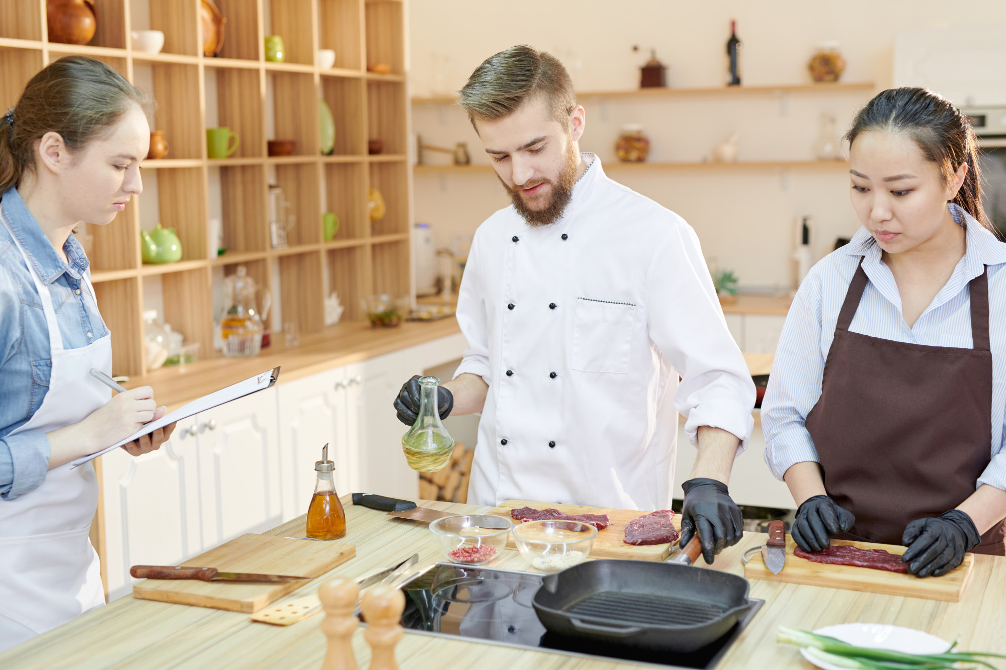 Chef guiding a student over a stove